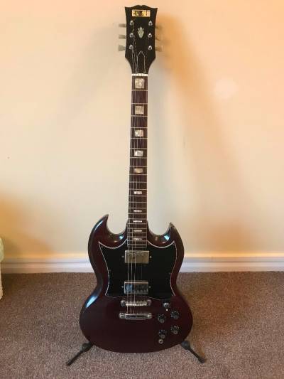 Guitare de forme SG de marque CMI avec son logo encore présent sur la tête.